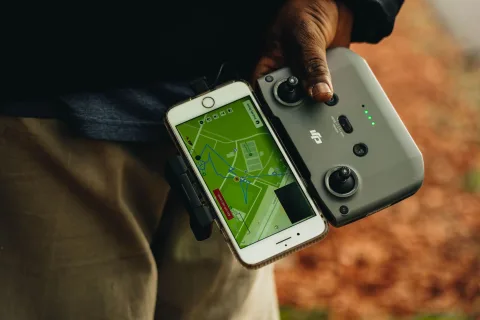 Un smartphone posé à côté d'une box internet moderne affichant des voyants lumineux de connexion Wi-Fi.