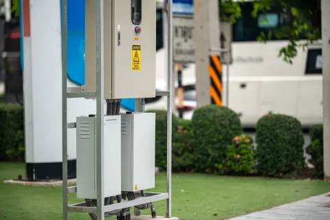 Une voiture électrique blanche en cours de recharge sur une borne publique en ville.