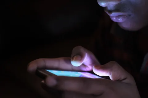 Une personne tient un smartphone affichant des icônes de logiciels libres et de protection des données.