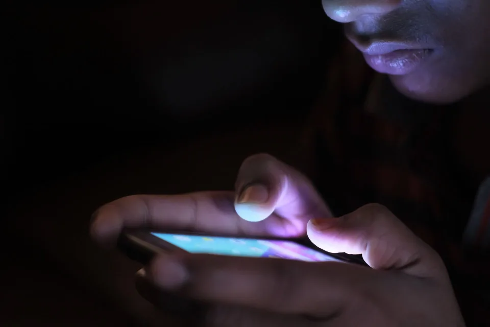 Une personne tient un smartphone affichant des icônes de logiciels libres et de protection des données.