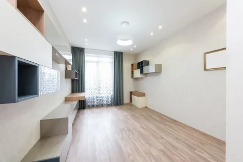 Une petite caméra de surveillance discrète posée sur une étagère en bois dans un salon moderne.