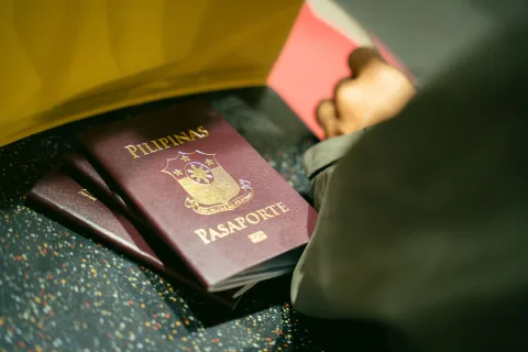 Une voyageuse présente sa pièce d'identité au comptoir d'embarquement d'un aéroport.