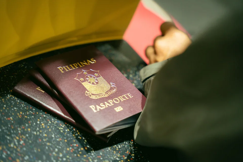 Une voyageuse présente sa pièce d'identité au comptoir d'embarquement d'un aéroport.