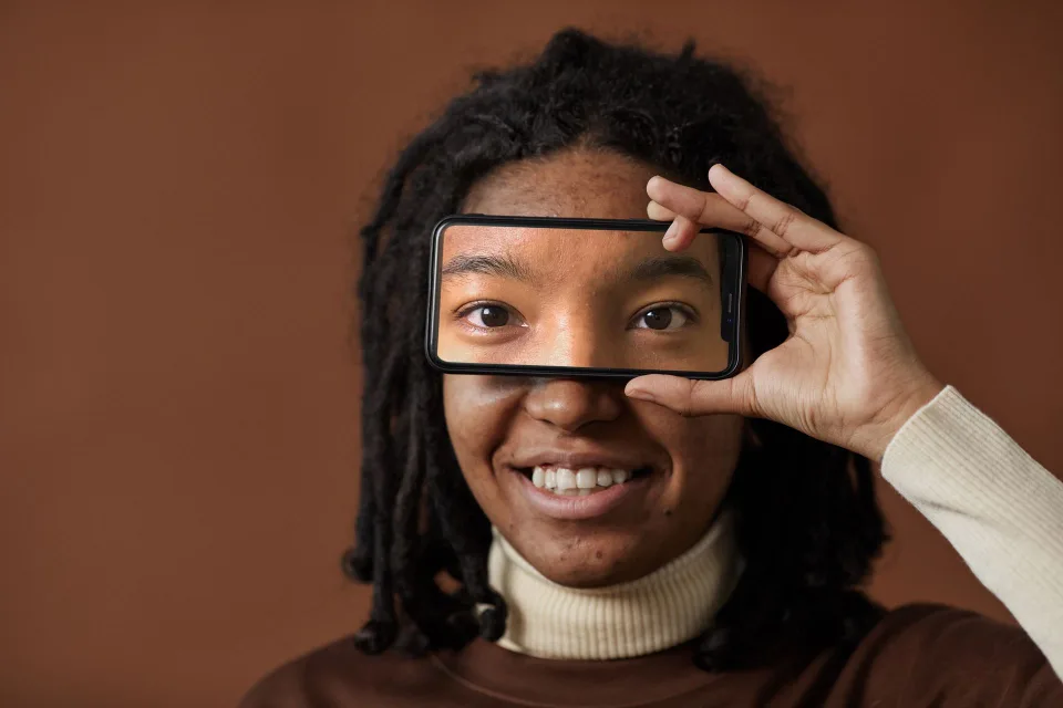 Une personne déverrouille son smartphone en utilisant la reconnaissance faciale pour se connecter à son compte en ligne.