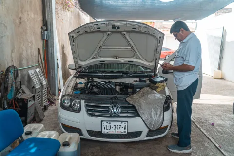 Un mécanicien explique les détails d'un devis d'entretien à un client dans un atelier automobile.