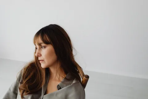 Portrait d'une femme avec une frange Birkin légère et des cheveux longs dégradés