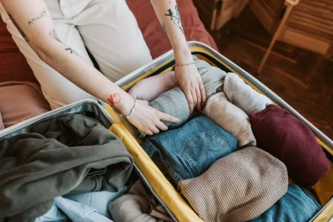Une valise ouverte bien rangée contenant des vêtements propres pliés avec soin.