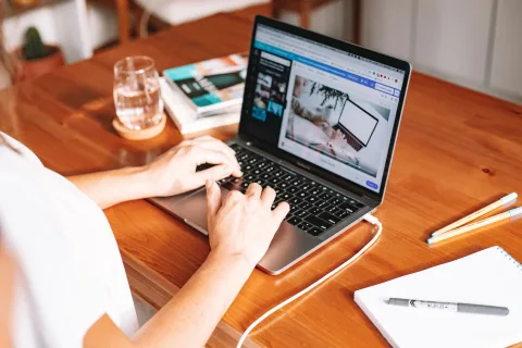 Une personne travaille sur un ordinateur portable affichant un document PDF à l'écran.