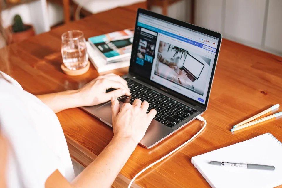 Une personne travaille sur un ordinateur portable affichant un document PDF à l'écran.