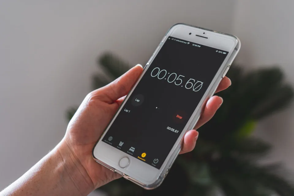 Un utilisateur modifiant les paramètres d'affichage de son iPhone pour économiser la batterie.