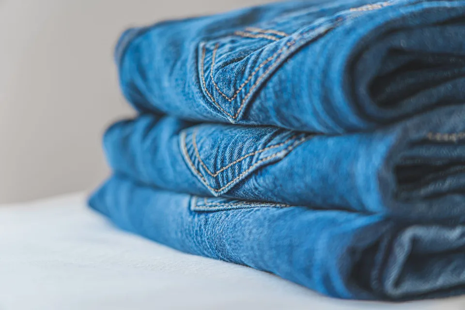 Un dressing parfaitement organisé avec des vêtements pliés verticalement et des cintres superposés.