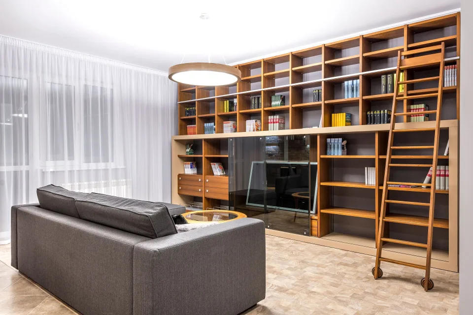 Un salon lumineux et parfaitement ordonné avec des étagères épurées et un canapé confortable.
