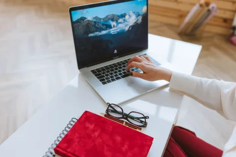 Une personne travaille sur son ordinateur portable dans un bureau moderne.