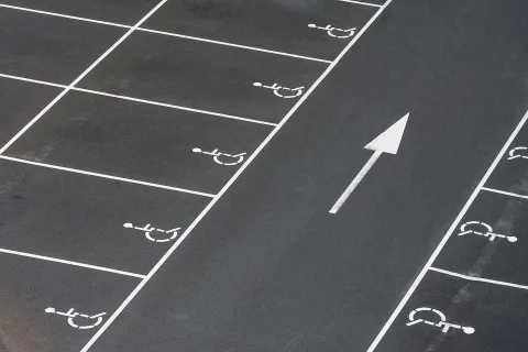 Une carte de stationnement pour personne handicapée posée derrière le pare-brise d'une voiture.