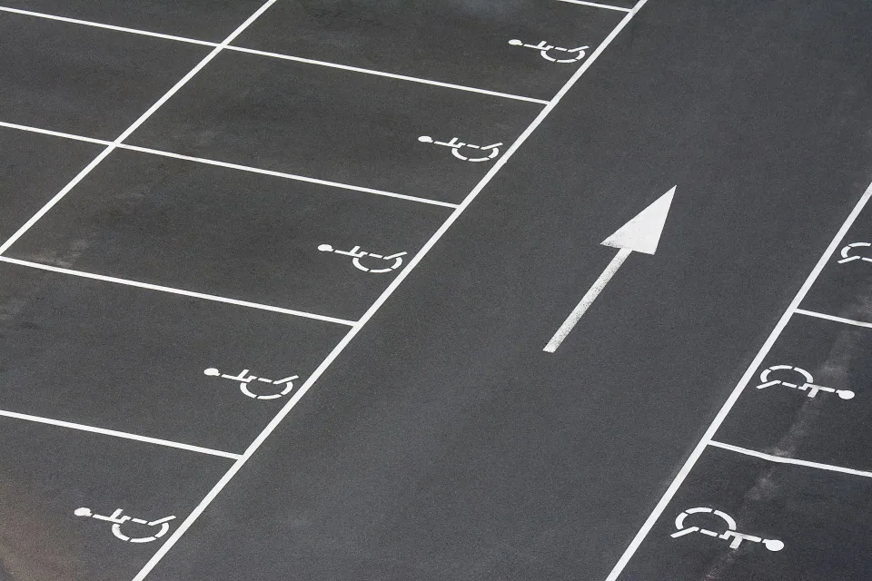 Une carte de stationnement pour personne handicapée posée derrière le pare-brise d'une voiture.