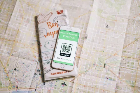 Une personne utilise son smartphone pour scanner sa carte d'identité posée sur une table.