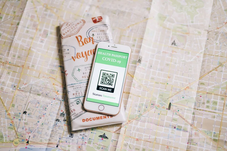 Une personne utilise son smartphone pour scanner sa carte d'identité posée sur une table.