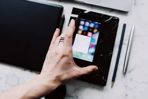 Un smartphone posé à côté d'une box internet moderne affichant des voyants lumineux de connexion actifs.