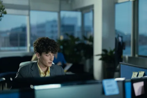 Un bureau minimaliste et aseptisé avec des cloisons vertes et un ordinateur rétro-futuriste.