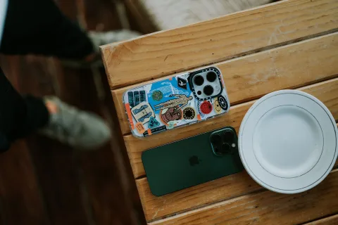 Un smartphone posé face contre table à côté d'une tasse de café.