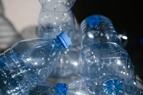Un absorbeur d'humidité artisanal fabriqué avec une bouteille en plastique et du gros sel posé dans un placard de rangement.