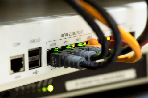 Un routeur internet moderne posé sur un meuble en bois diffusant un signal stable