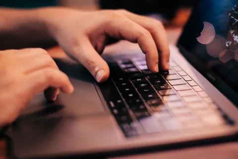 Une personne travaille sur un ordinateur portable affichant un traitement de texte gratuit.