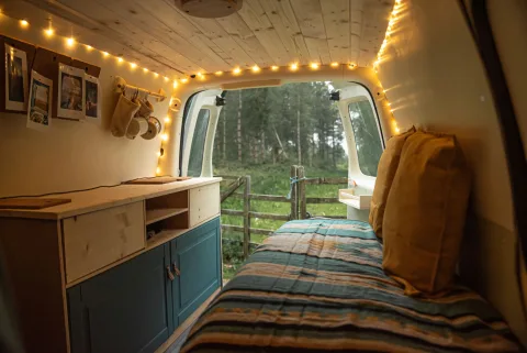 Intérieur d une petite voiture citadine transformée en couchage confortable avec matelas en mousse et rangements.