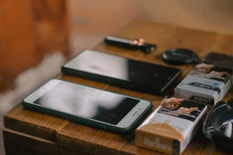 Un smartphone posé face contre table à côté d'un carnet de notes.