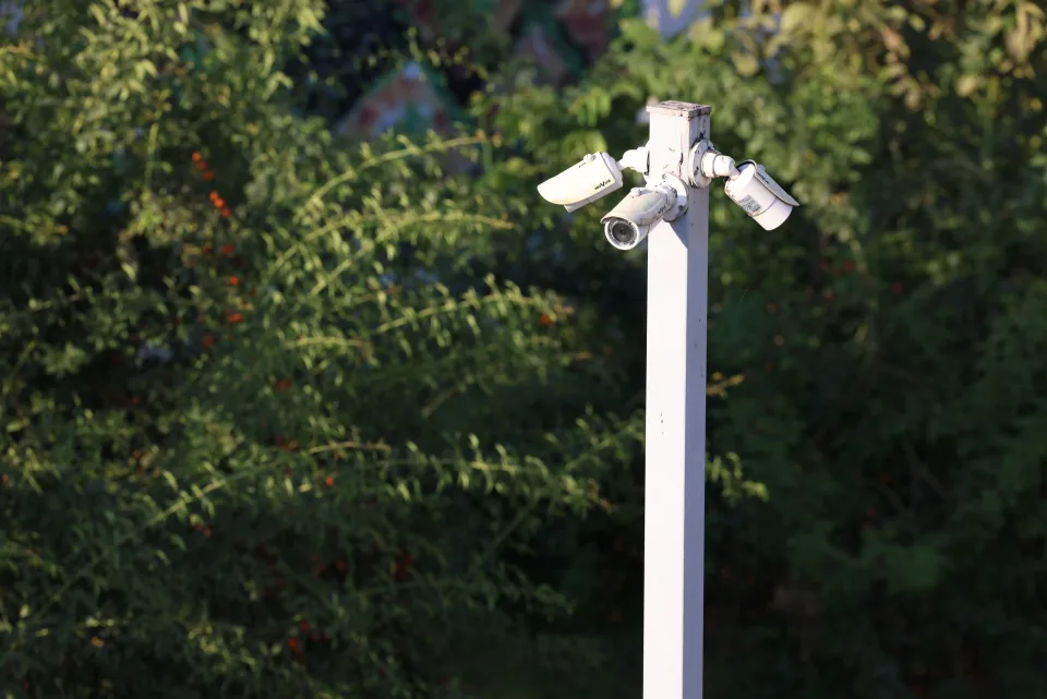 Une caméra de sécurité connectée blanche installée sur le mur extérieur en bois d une maison moderne