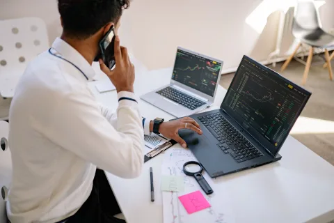 Un ordinateur portable affichant trois fenêtres de discussion d'assistants virtuels sur un bureau épuré.