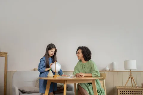 Une suspension boule en papier personnalisée avec des textures minérales suspendue au-dessus d'une table.