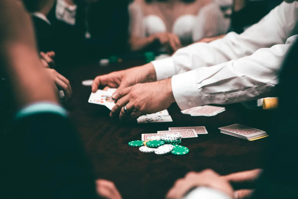 Deux personnes jouent à un jeu de cartes à collectionner sur une table en bois avec des decks protégés.