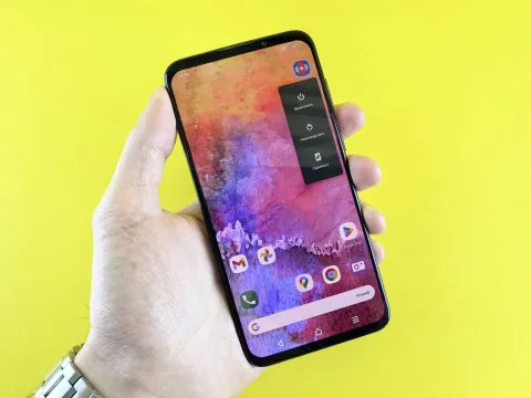 Une main manipulant les réglages de confidentialité sur l'écran d'un smartphone Samsung Galaxy.