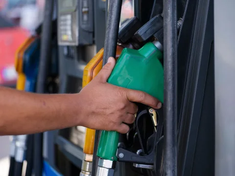 Une personne remplit le réservoir de sa voiture avec un pistolet d'essence à une station-service.