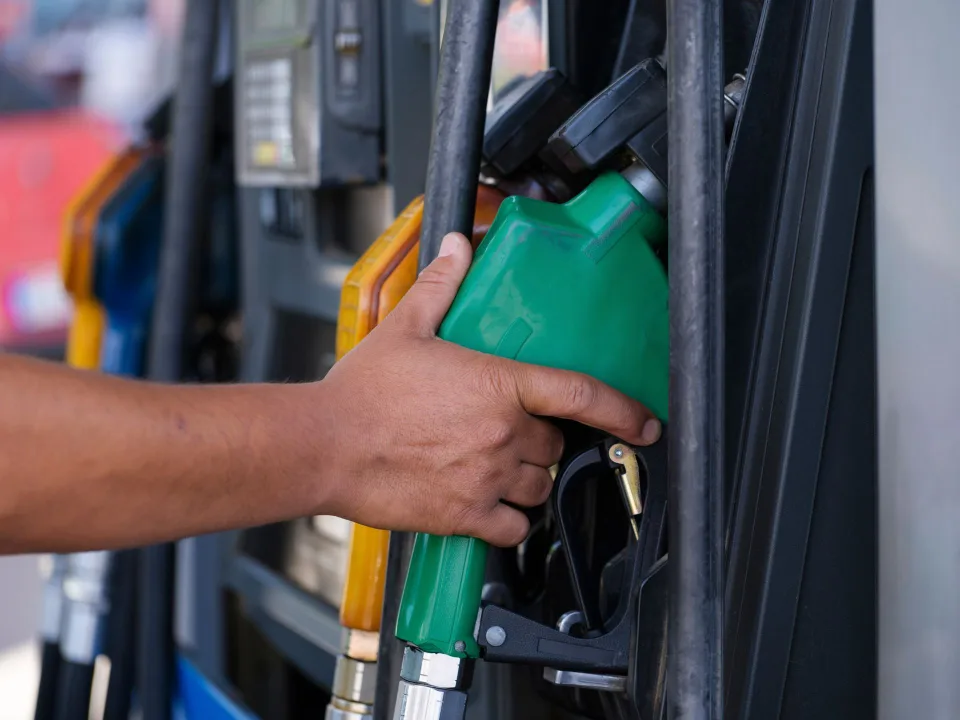 Une personne remplit le réservoir de sa voiture avec un pistolet d'essence à une station-service.