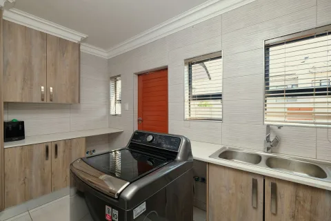 Un lave-linge moderne installé proprement sous un plan de travail de cuisine.