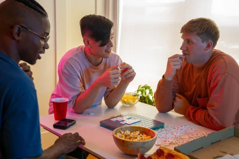 Un groupe d'amis cherchant des indices dans un salon décoré d'enveloppes et de mystères.