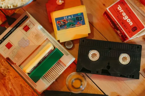 Une collection de jeux vidéo rétro alignés sur une étagère, certains sont protégés par des boîtiers en plastique rigide.