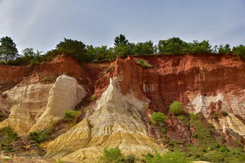 Falaises sculptées de couleur ocre et rouge sous un ciel bleu dans le Luberon