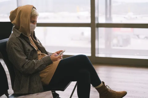 Une personne tient un smartphone affichant un QR code d'activation d'eSIM dans un terminal d'aéroport.