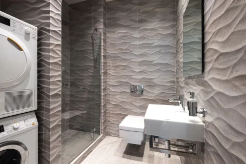 Des vêtements de voyage suspendus pour sécher sur un cintre dans une salle de bain d'hôtel.
