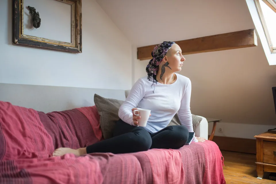Une personne assise confortablement près d'une fenêtre, regardant dehors sans distraction.