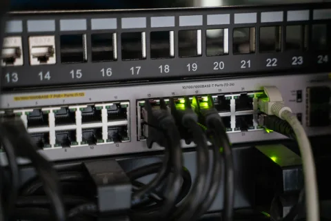 Un routeur internet moderne avec des voyants lumineux allumés sur un meuble en bois.