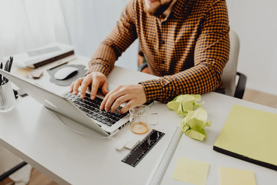 Une personne travaille sur un ordinateur portable dans un bureau épuré pour configurer son IA.