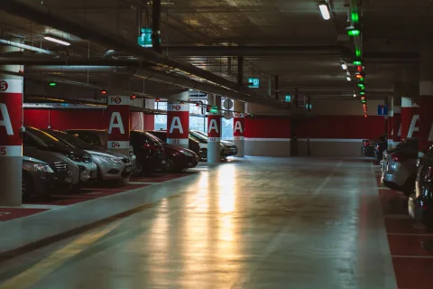 Des dizaines de voitures garées sur un parking extérieur sécurisé près d'un aéroport.