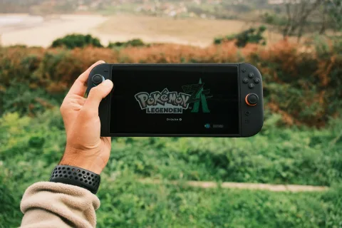 Deux personnes assises sur un canapé jouant ensemble à la console Nintendo Switch