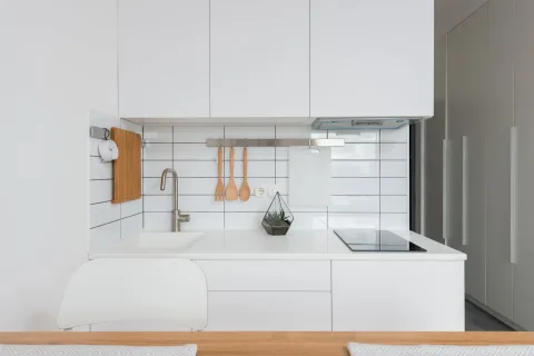 Pose de dalles adhésives effet carrelage blanc métro sur le mur d'une cuisine moderne