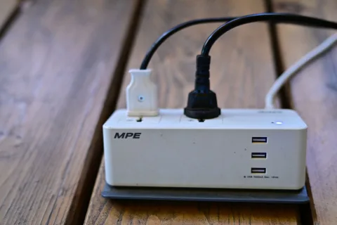 Une prise connectée intelligente insérée dans une prise murale alimentant un appareil ménager.