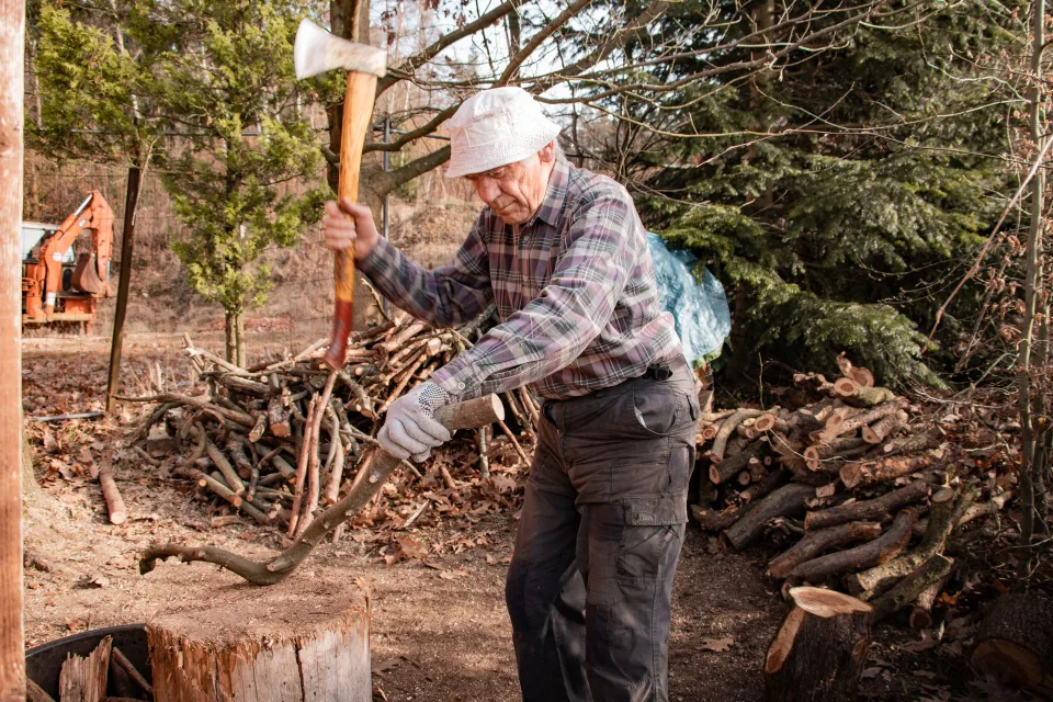 Un jardinier utilise un broyeur de végétaux pour transformer des branches en paillis fertile.